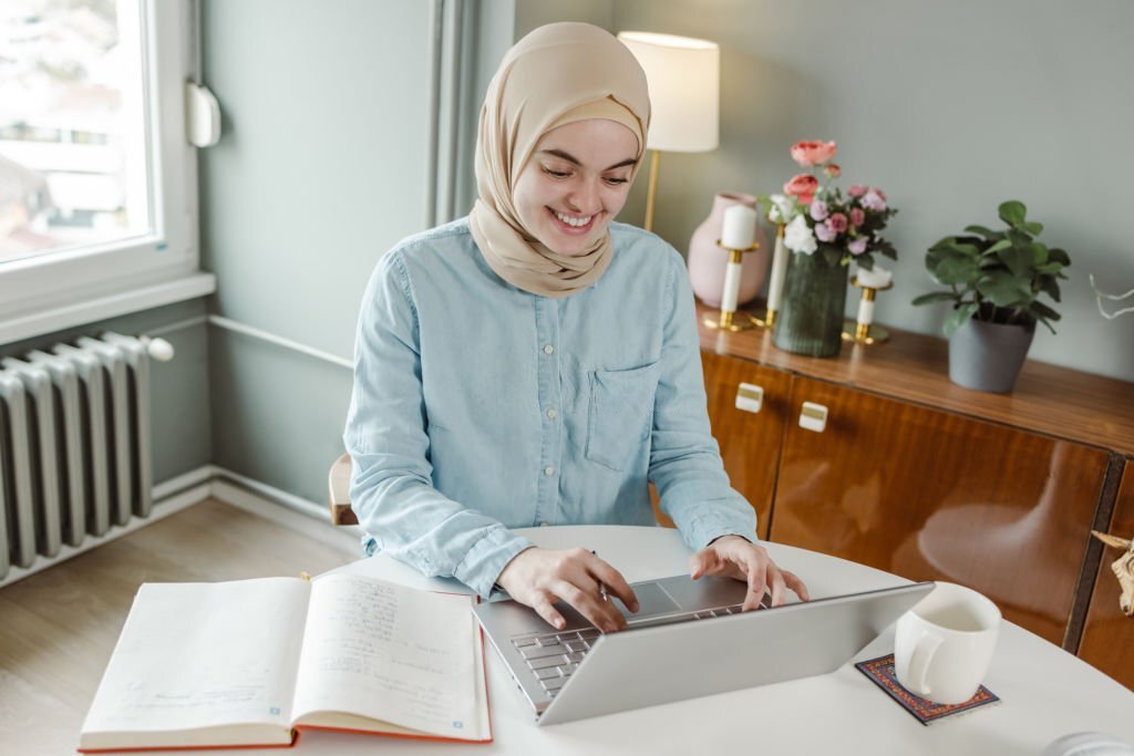Young woman at home, using laptop.
